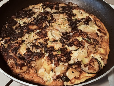 Omelette with zucchini and onions in a frying panの写真素材