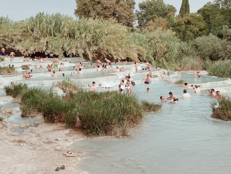 People bathe in a hot spring on the shoreの写真素材