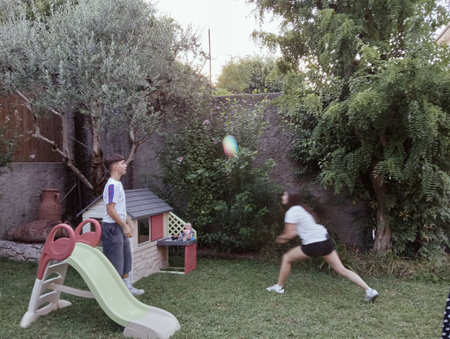children playing on a playground in the yard of a country house.