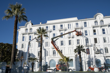 Sanremo, Italy - January 05, 2018: Workers in the crane's basket renovate the facade of an ancient white palaceのeditorial素材