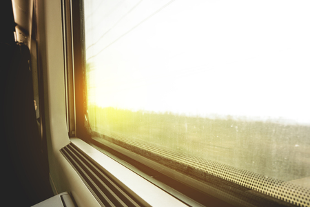Traveling by train: look out at the window at a moving landscape at sunset