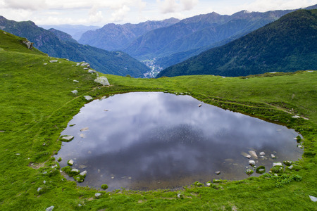 Small mountain lake in the background. This pond is called Lago del Pizzo, in Valsesia, Piedmont...