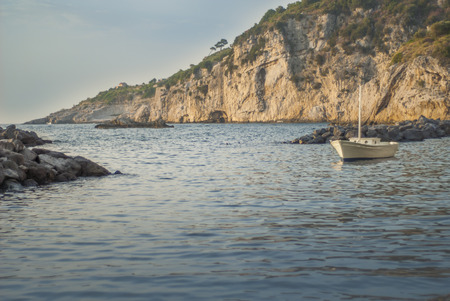Sea, sky and rocks together with a small boat
