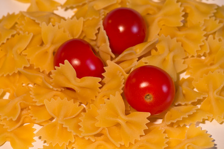 Raw pasta with cheery tomatoesの写真素材