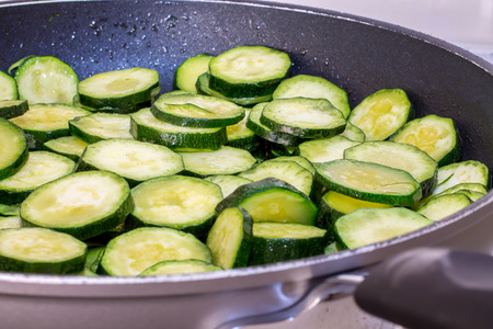 closeup of sliced zucchini while cooking in the panの写真素材
