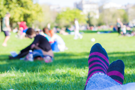 closeup of colored socks of a teenager who is resting in a parkの写真素材