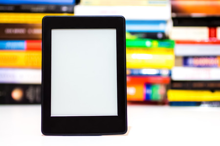 E-book reader on background of old books
