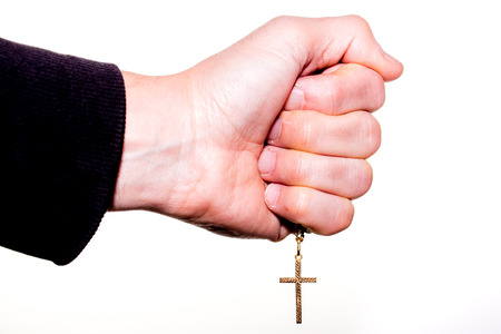 Hand holds a chain with gold crucifix, isolated on whiteの写真素材