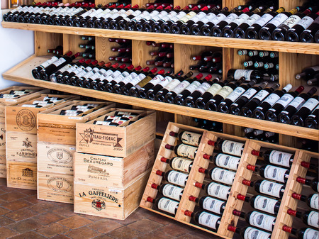 Saint Emilion, FRANCE - APRIL 13, 2015 - wooden racks with red wine bottles in a shop