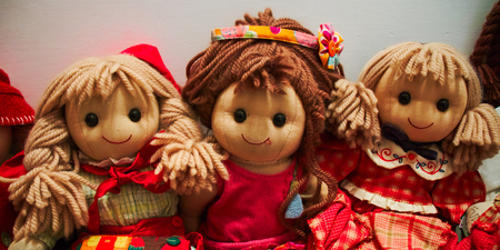 Three smiling dolls with red dressesの写真素材