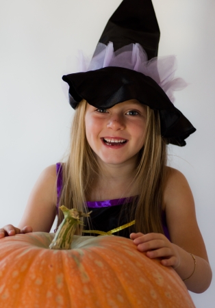 little witch with pumpkin in haloween partyの写真素材