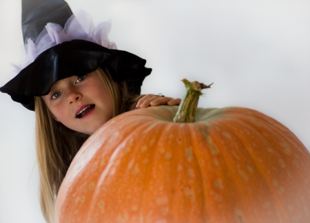 little witch with pumpkin in haloween partyの写真素材