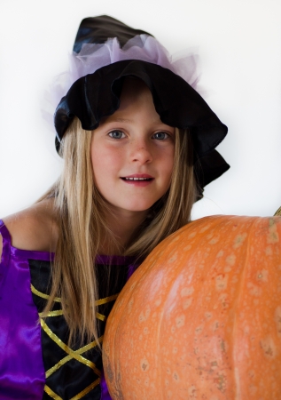 little witch with pumpkin in haloween partyの写真素材