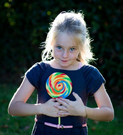 little girl with lollipop candy in natureの写真素材