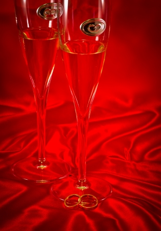 wedding champagne glasses on red fabricの写真素材