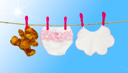 clothesline with baby clothes and teddy bearの写真素材