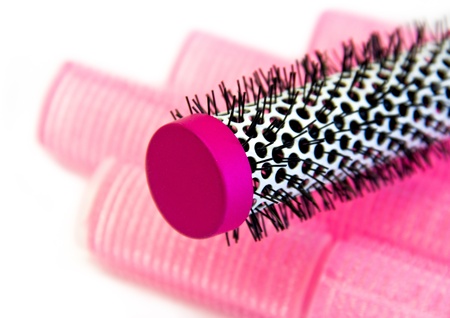 pink hairbrush and curlers isolated on whiteの写真素材