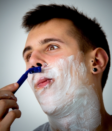 portrait of a young man shavingの写真素材