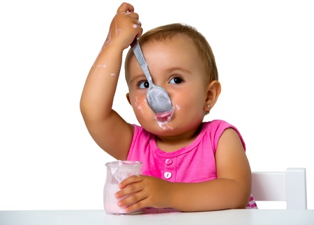 girl eating yogurt isolated on whiteの写真素材