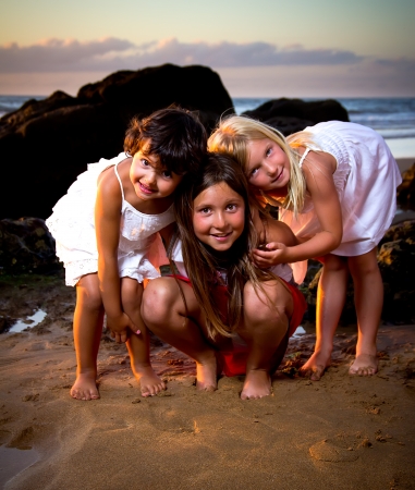 three little girls in a sunset on the beachの写真素材