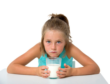 little girl with glass of milk isolated on whiteの写真素材