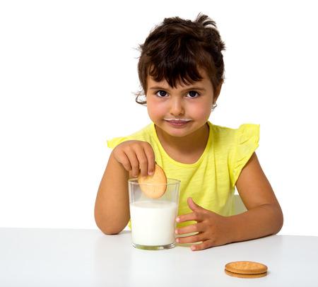 little girl with glass of milk isolated on whiteの写真素材