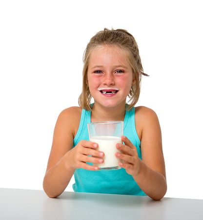 little girl with glass of milk isolated on whiteの写真素材