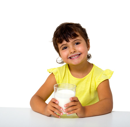 little girl with glass of milk isolated on whiteの写真素材
