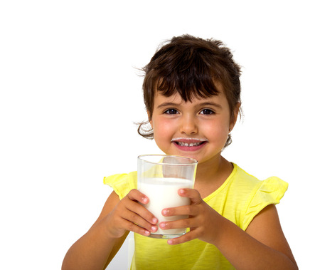 little girl with glass of milk isolated on whiteの写真素材