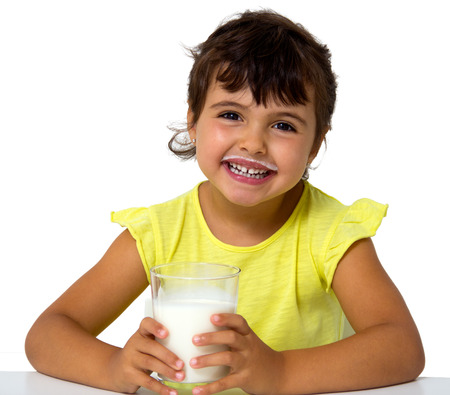 little girl with glass of milk isolated on whiteの写真素材