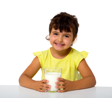 little girl with glass of milk isolated on whiteの写真素材