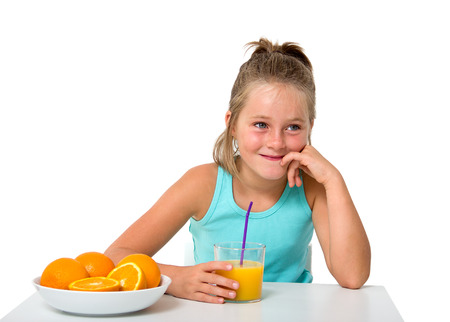 little girl with glass of orange juice isolated on whiteの写真素材