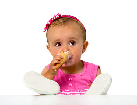 baby eating an icecream isolated on whiteの写真素材