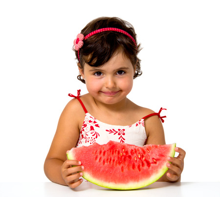 little girl eating watermelon isolated on whiteの写真素材
