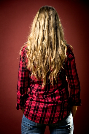 portrait of a middle aged woman back on a red backgroundの写真素材