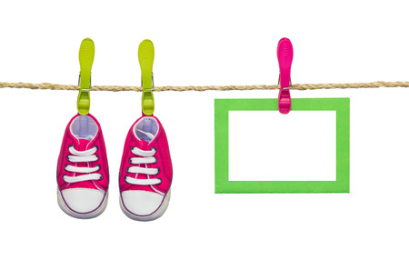 baby shoes in clothesline with card isolated on whiteの写真素材