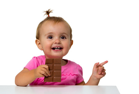 baby eating chocolate isolated on whiteの写真素材