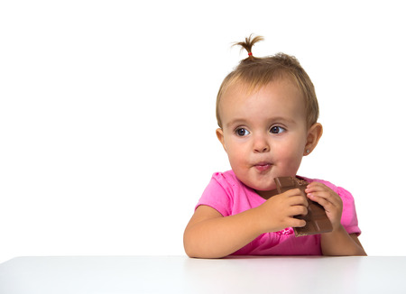 baby eating chocolate isolated on whiteの写真素材