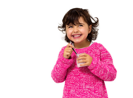 girl eating yogurt isolated on whiteの写真素材