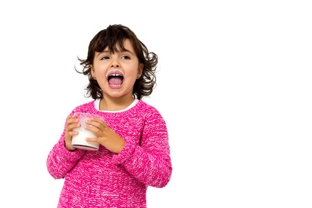 little girl with glass of milk isolated on whiteの写真素材