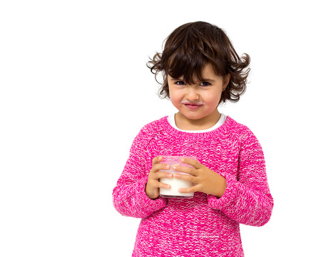 little girl with glass of milk isolated on whiteの写真素材