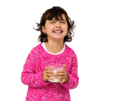 little girl with glass of milk isolated on whiteの写真素材