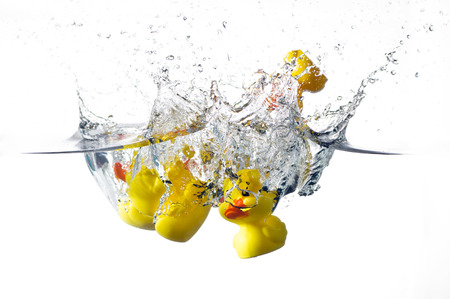 rubber ducks splashing in the waterの写真素材