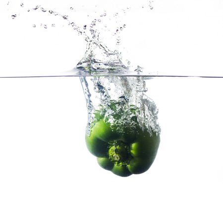green pepper falling and splashing into clear water.の写真素材