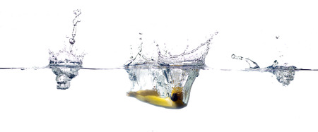 banana falling and splashing into clear water.の写真素材