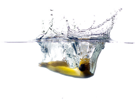 banana falling and splashing into clear water.の写真素材