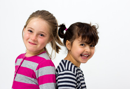 two happy little girls isolated on whiteの写真素材