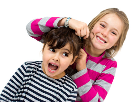 two little girls combing isolated on whiteの写真素材