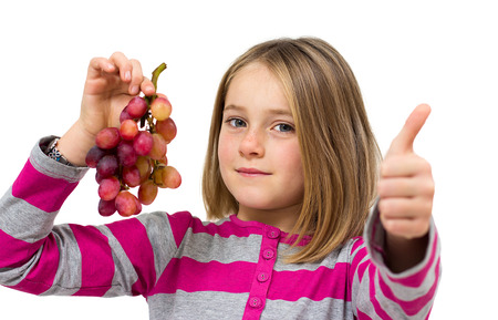 little girl with grapes isolated on whiteの写真素材