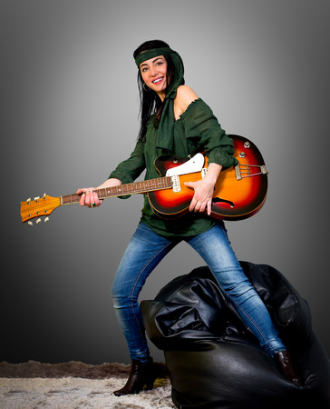 Woman posing with an electric guitarの写真素材